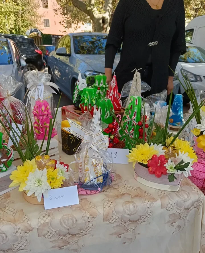 Il banco del mercatino con candele e fiori